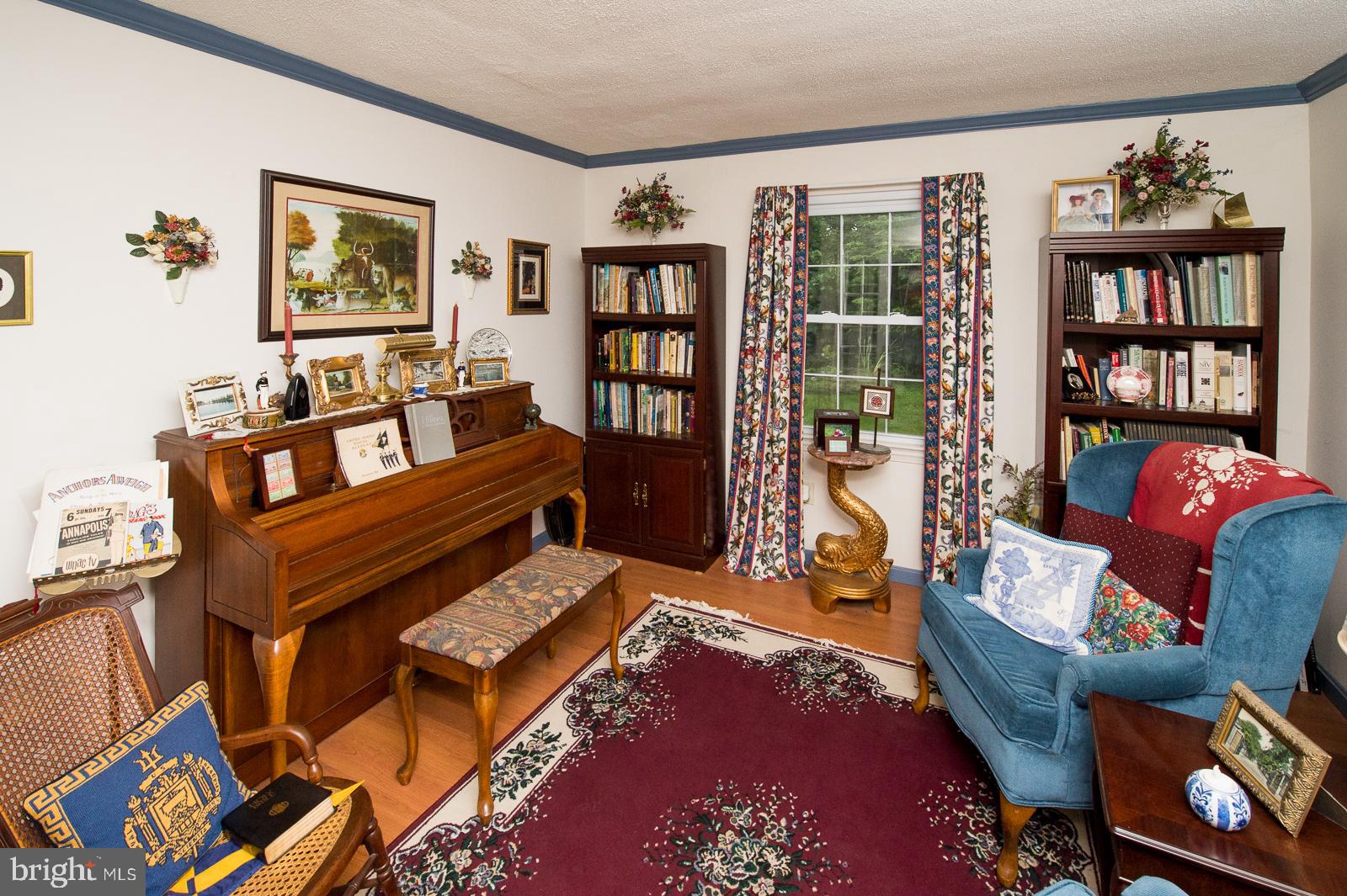 1251 Turkey Point Road Edgewater, MD 21037 - Photo 4 of 32 a living room with furniture a bookshelf and a book shelf