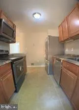 a kitchen that has a sink a microwave a stove and cabinets