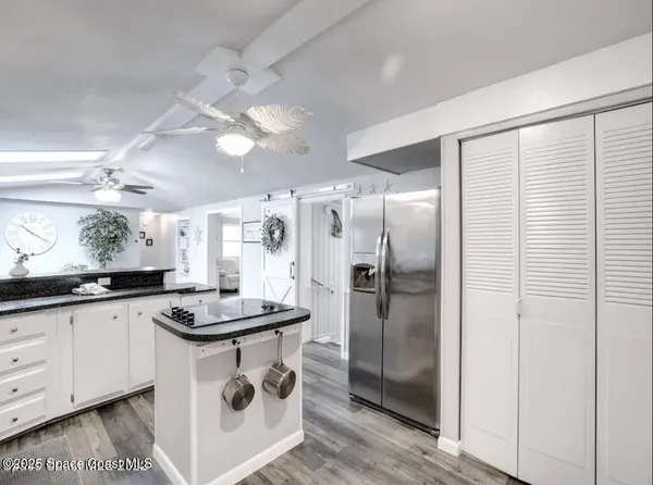 a kitchen with granite countertop a sink a counter space and stainless steel appliances