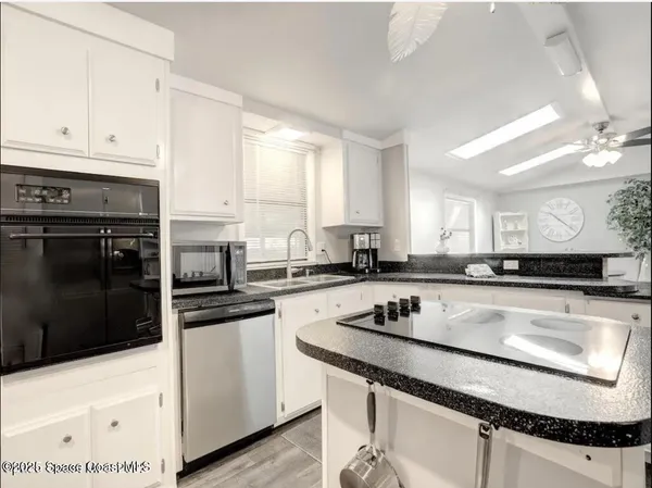 a kitchen with a sink a stove and cabinets