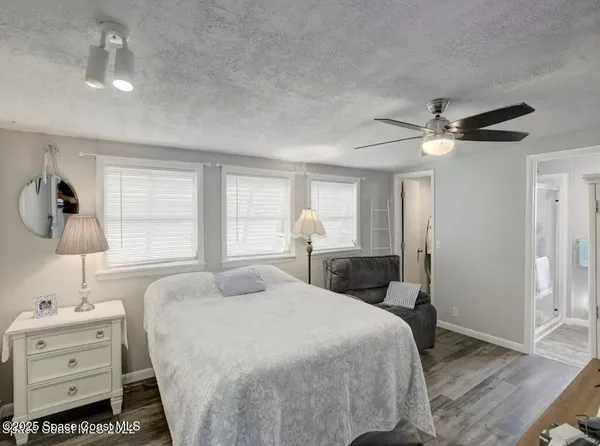 a spacious bedroom with a bed and a chandelier