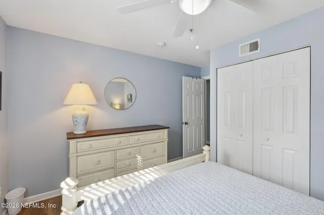 a bedroom with a bed and a lamp on dresser