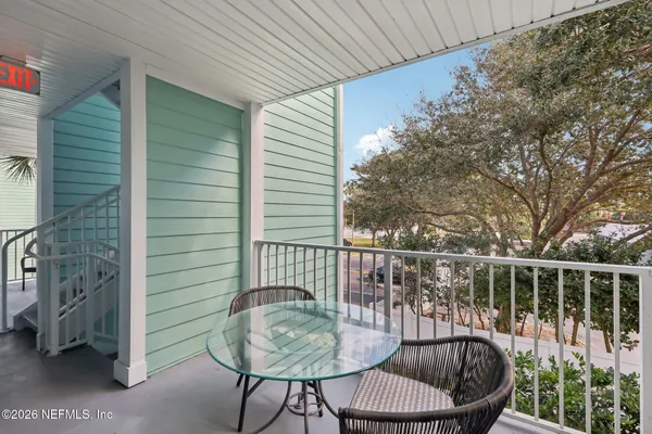 a balcony with table and chairs