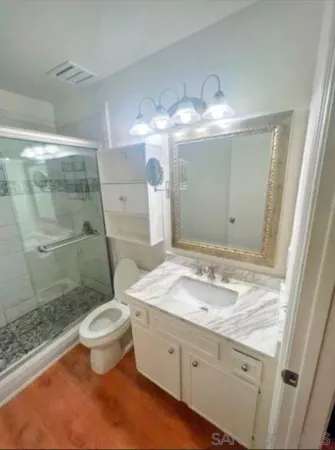a bathroom with a granite countertop sink toilet and shower