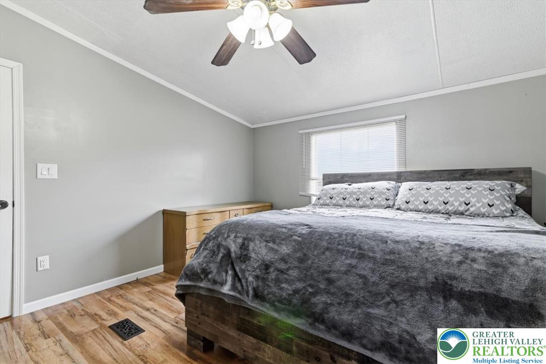 634 Main Road Lehighton, PA 18235 - Photo 21 of 39 Relax in this well-lit bedroom featuring rich hardwood flooring and a stylish wooden bed frame.
