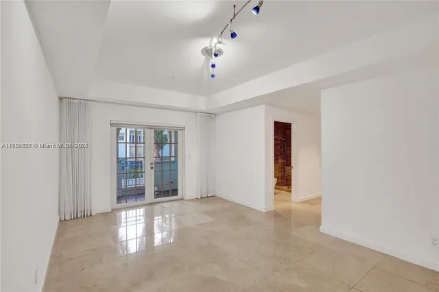 an empty room with windows and chandelier