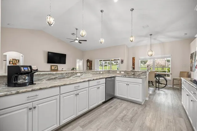 a kitchen with granite countertop a sink cabinets and wooden floor