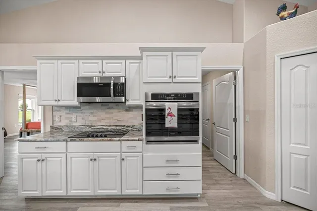 a kitchen with stainless steel appliances white cabinets and a refrigerator