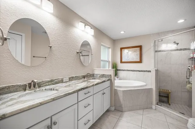 a spacious bathroom with a double vanity sink double mirror and bathtub