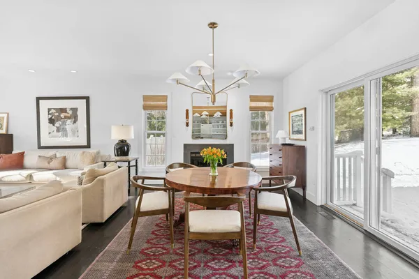 a living room with furniture two window and a dining table