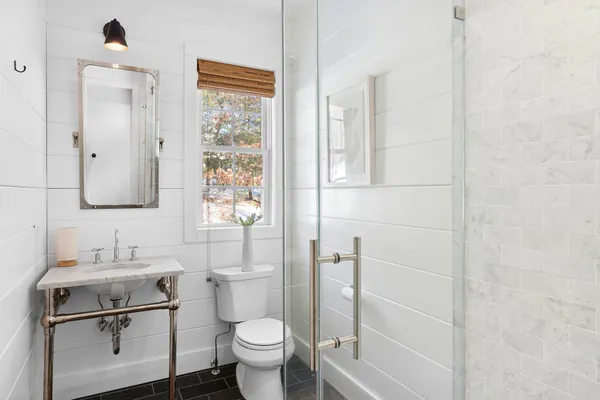 a bathroom with a toilet sink and mirror