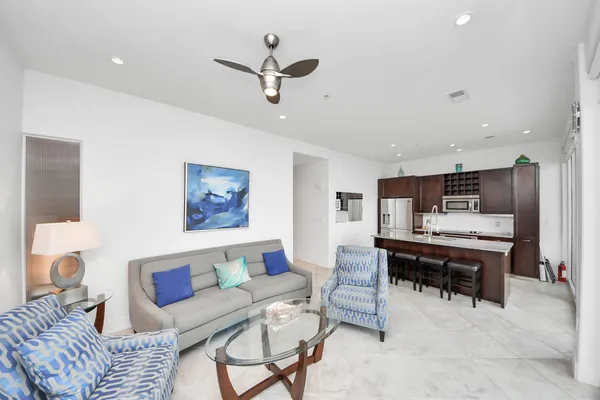 a living room with furniture and a dining table with kitchen view