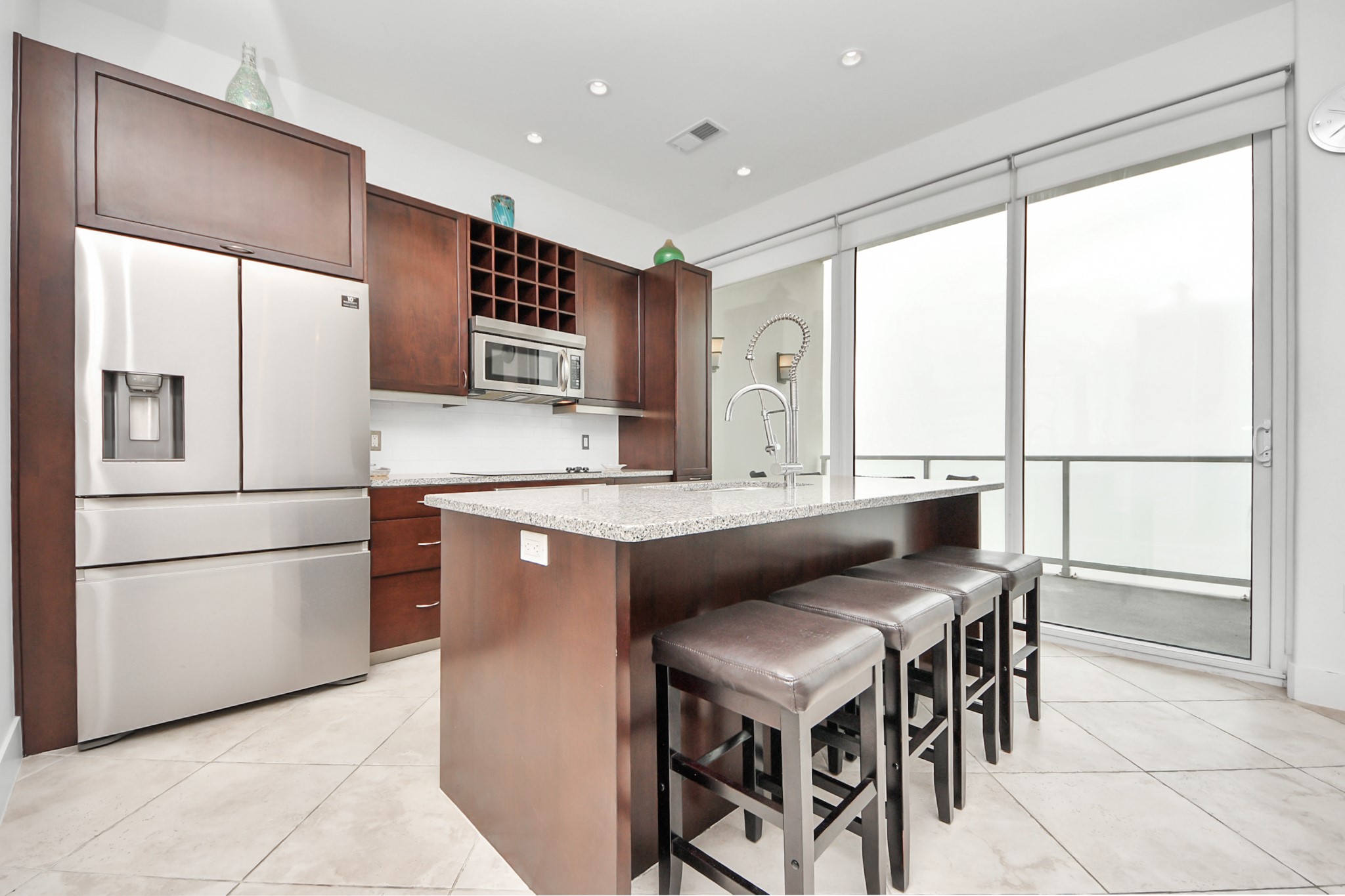 10327 Termini-San Luis Pass Road, Unit 617 Galveston, TX 77554 - Photo 5 of 50 a kitchen with stainless steel appliances granite countertop a table chairs and a refrigerator