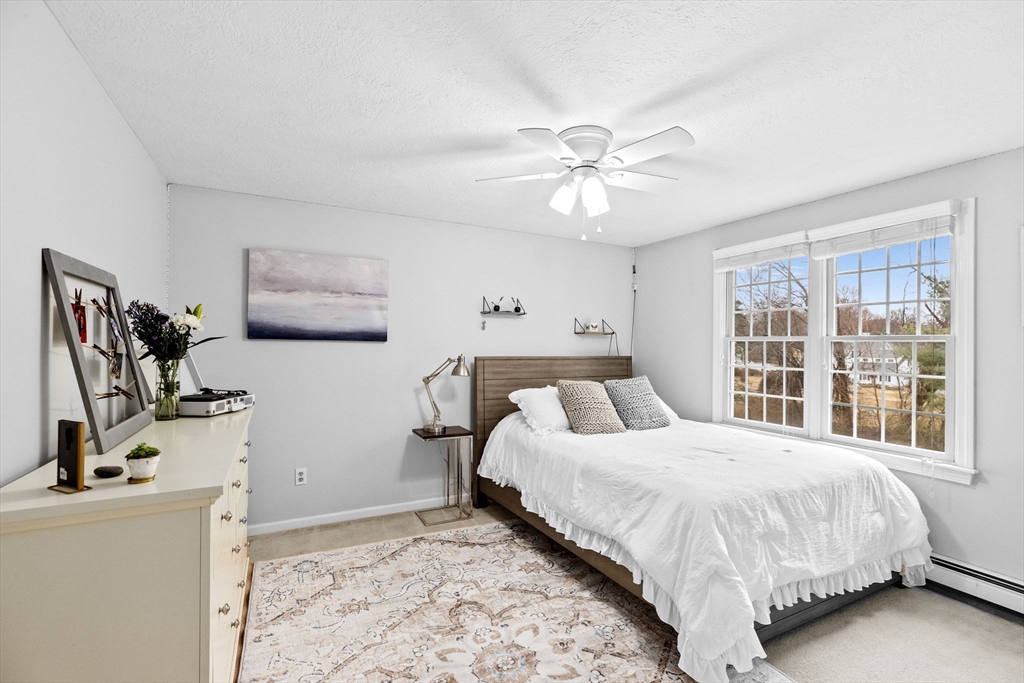 9 Windward Lane Scituate, MA 02066 - Photo 16 of 37 a bedroom with a bed flat screen tv and a large window