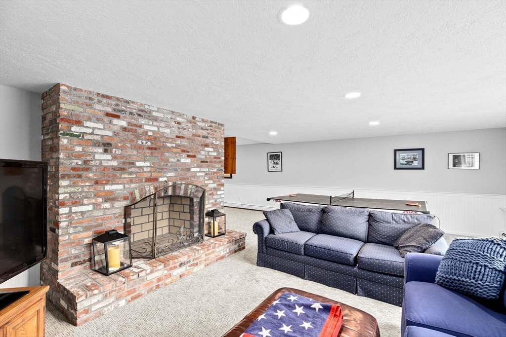 9 Windward Lane Scituate, MA 02066 - Photo 28 of 37 a living room with furniture a flat screen tv and a fireplace