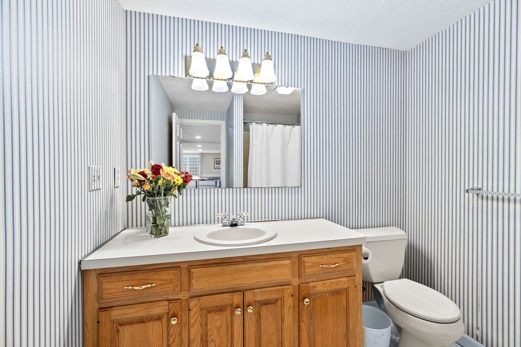 9 Windward Lane Scituate, MA 02066 - Photo 29 of 37 a bathroom with a sink and a mirror with toilet