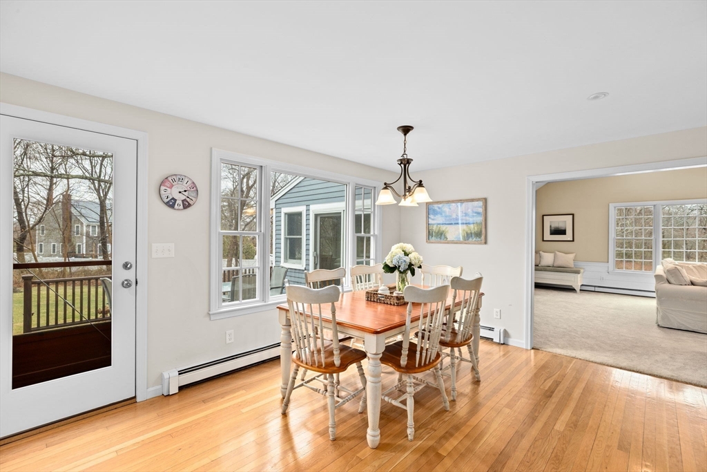 9 Windward Lane Scituate, MA 02066 - Photo 8 of 37 a dining room with furniture a chandelier and wooden floor