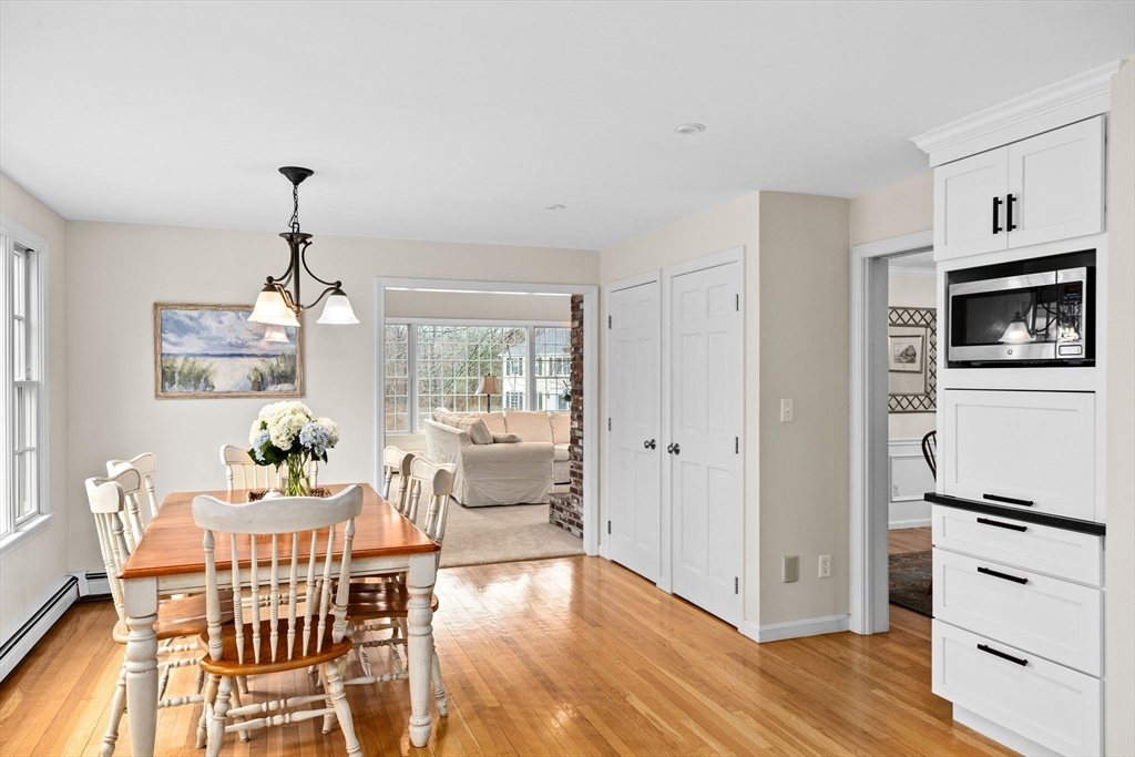 9 Windward Lane Scituate, MA 02066 - Photo 9 of 37 a dining room with furniture a chandelier and wooden floor