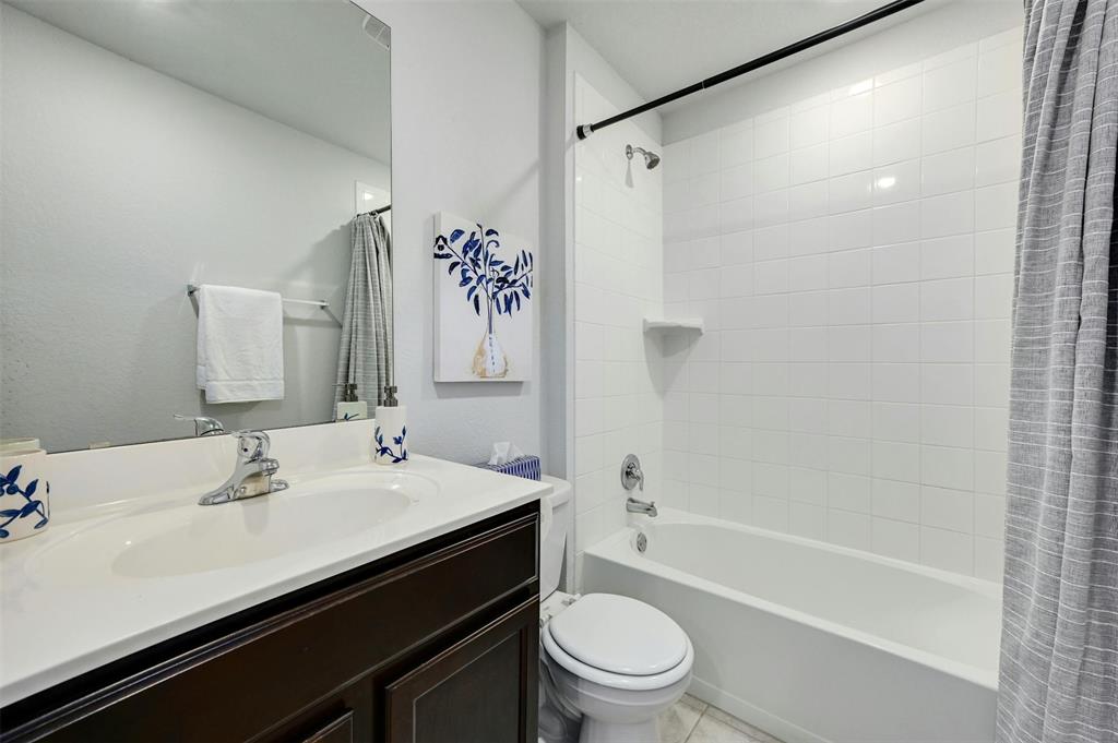 1045 Taggart Trail Jarrell, TX 76537 - Photo 13 of 19 Full bathroom featuring shower / bath combination with curtain, vanity, and light tile patterned floors