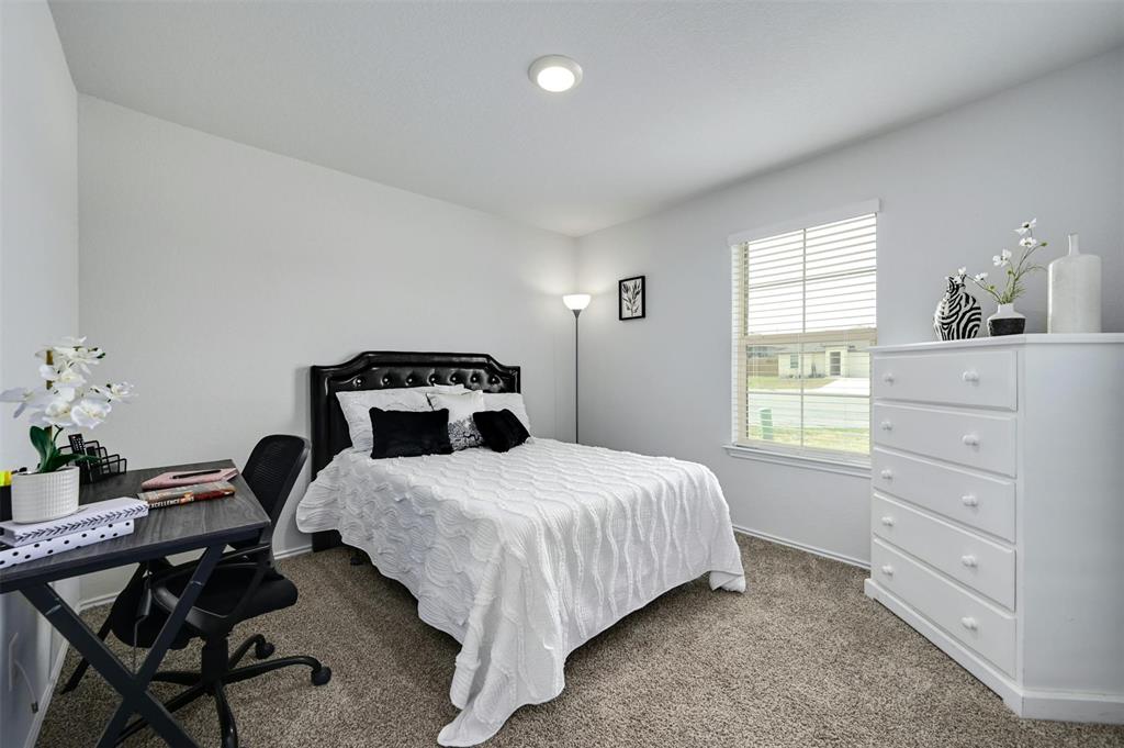 1045 Taggart Trail Jarrell, TX 76537 - Photo 14 of 19 Carpeted bedroom featuring baseboards and a desk