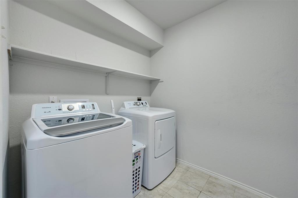 1045 Taggart Trail Jarrell, TX 76537 - Photo 16 of 19 Laundry room with washer and clothes dryer and light tile patterned floors