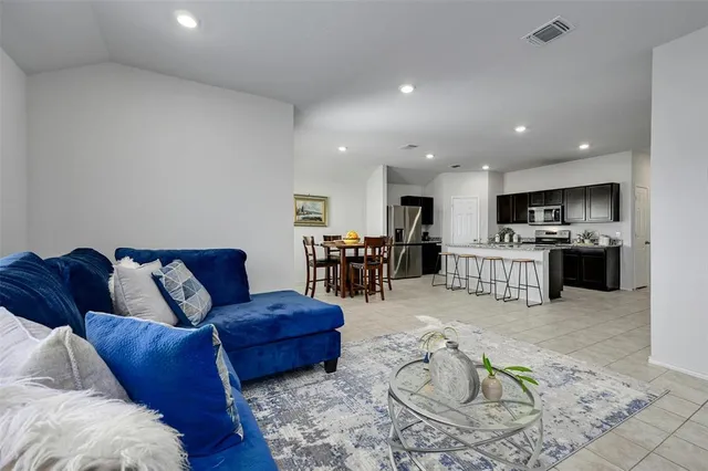 a bedroom with a bed a couch and a flat screen tv