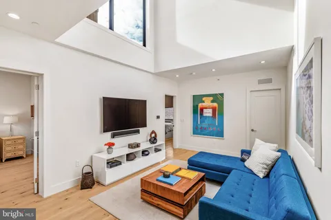a bedroom with a bed and a flat tv screen on dresser