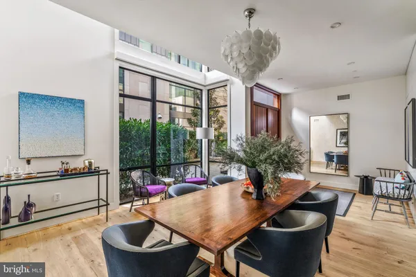 a kitchen with stainless steel appliances a refrigerator a stove a sink and a dining table with wooden floor