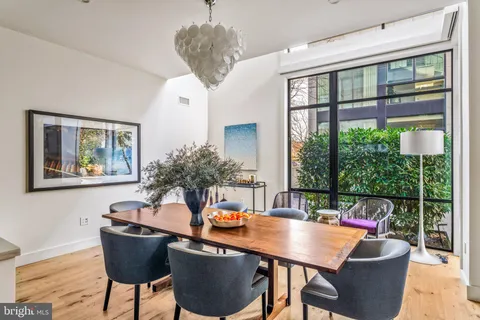 a dining room with furniture a chandelier and wooden floor