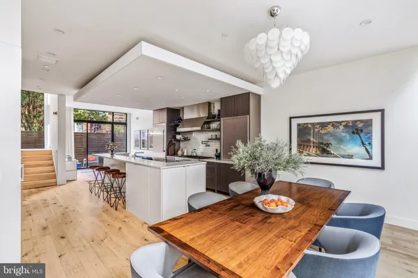 a large kitchen with stainless steel appliances a sink stove and cabinets