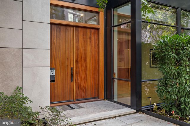 a kitchen with stainless steel appliances a refrigerator a stove a sink and a dining table with wooden floor