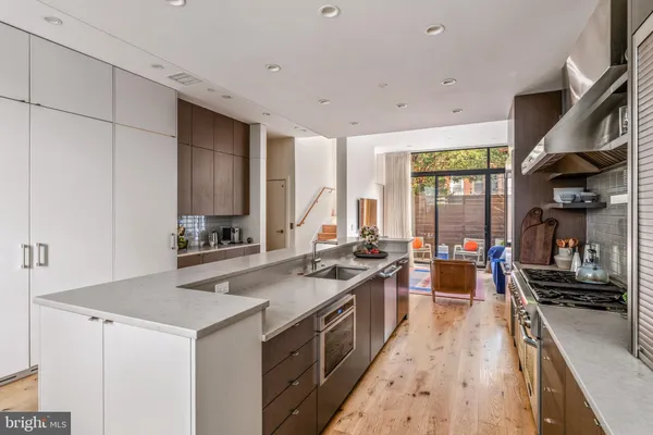 a kitchen with stove a sink dishwasher and cabinets with wooden floor