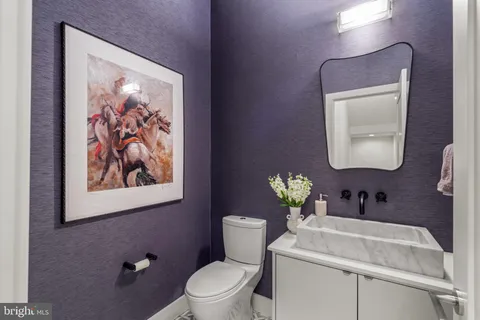 a bathroom with a toilet a sink and mirror