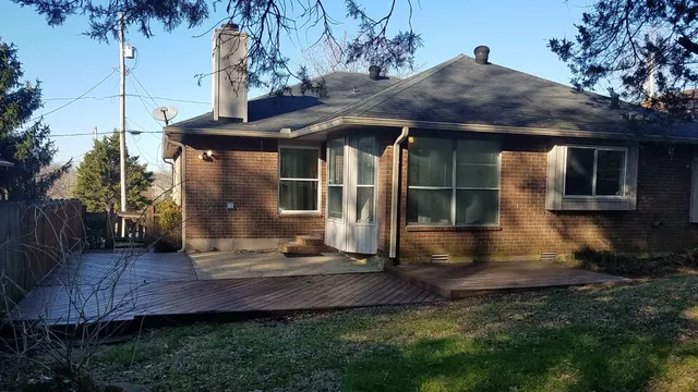 a view of house with backyard and outdoor seating
