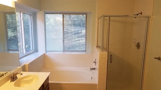 a bathroom with a tub sink and shower
