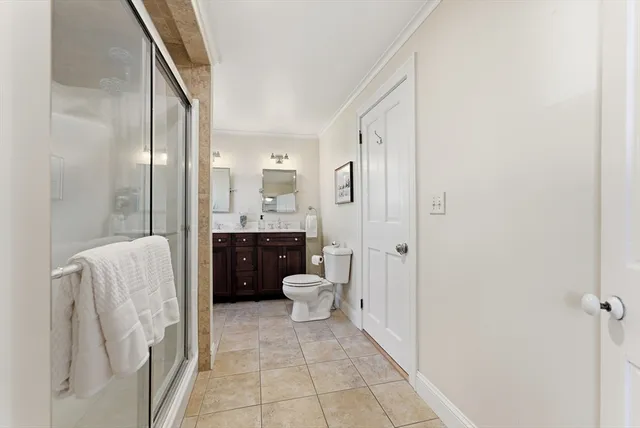 a bathroom with a double vanity sink toilet and shower