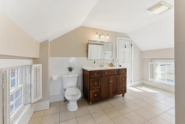 a bathroom with a sink vanity mirror and toilet
