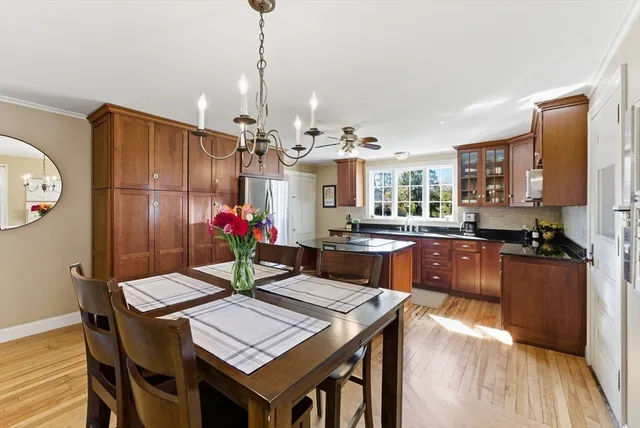 a view of a dining room with furniture a kitchen and chandelier