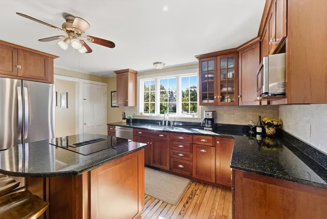 a kitchen with stainless steel appliances granite countertop a sink refrigerator stove and microwave