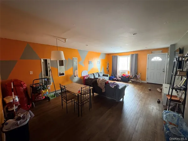 a living room with furniture a large window and wooden floor