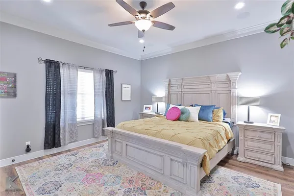a bedroom with a large bed and a chandelier