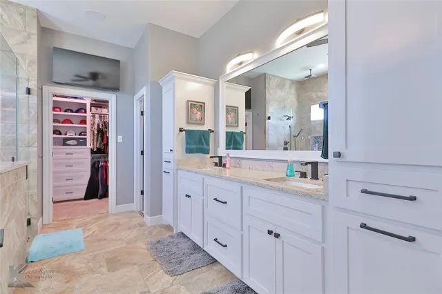 a spacious bathroom with a granite countertop sink mirror and