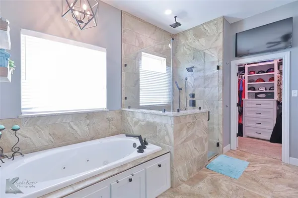 a bathroom with a tub sink and mirror
