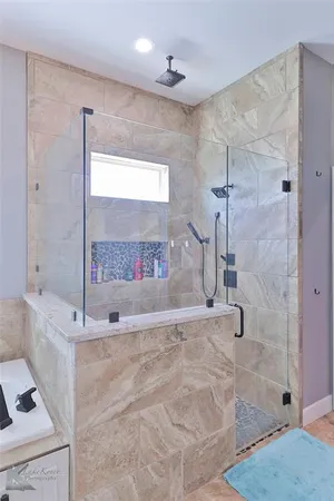 a spacious bathroom with a granite countertop shower a sink and a mirror
