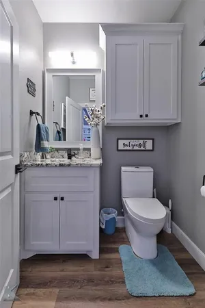 a bathroom with a toilet sink and mirror