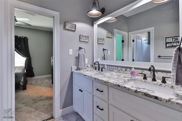 a bathroom with a granite countertop sink a toilet and a mirror