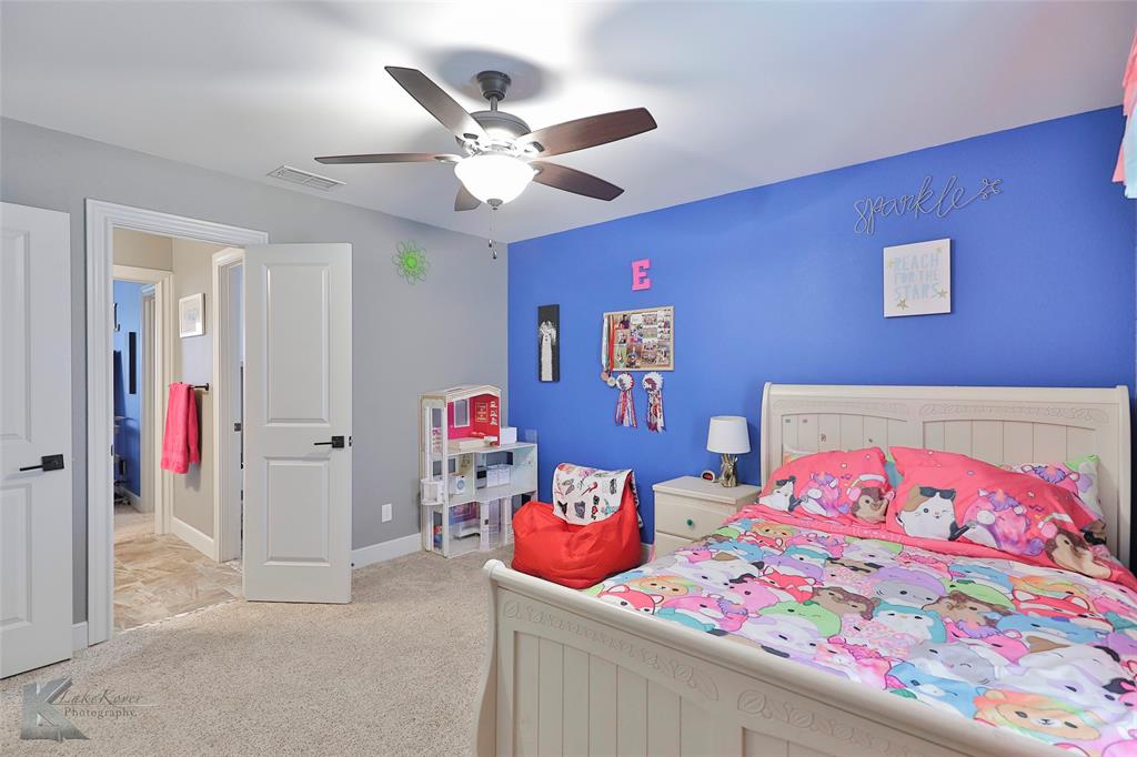 125 Wallace Court Tuscola, TX 79562 - Photo 27 of 40 a bedroom with a bed and a chandelier