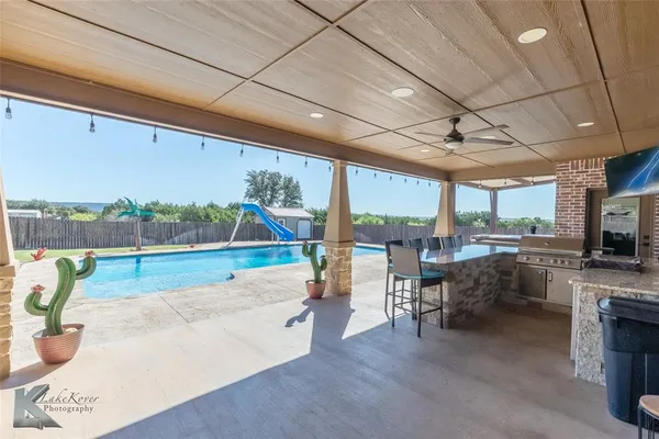 a view of a living room and kitchen floor to ceiling windows