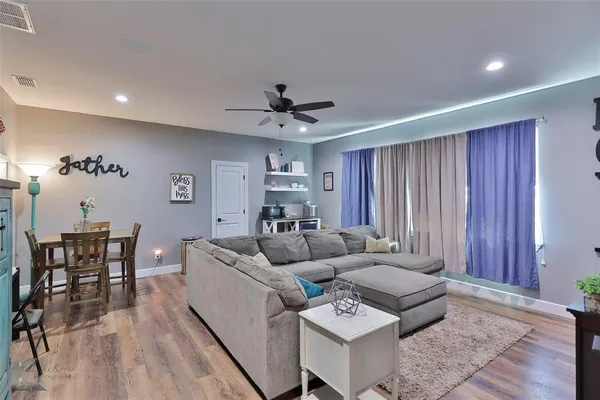 a living room with furniture and wooden floor