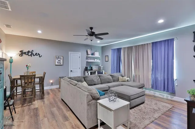 a living room with furniture and wooden floor